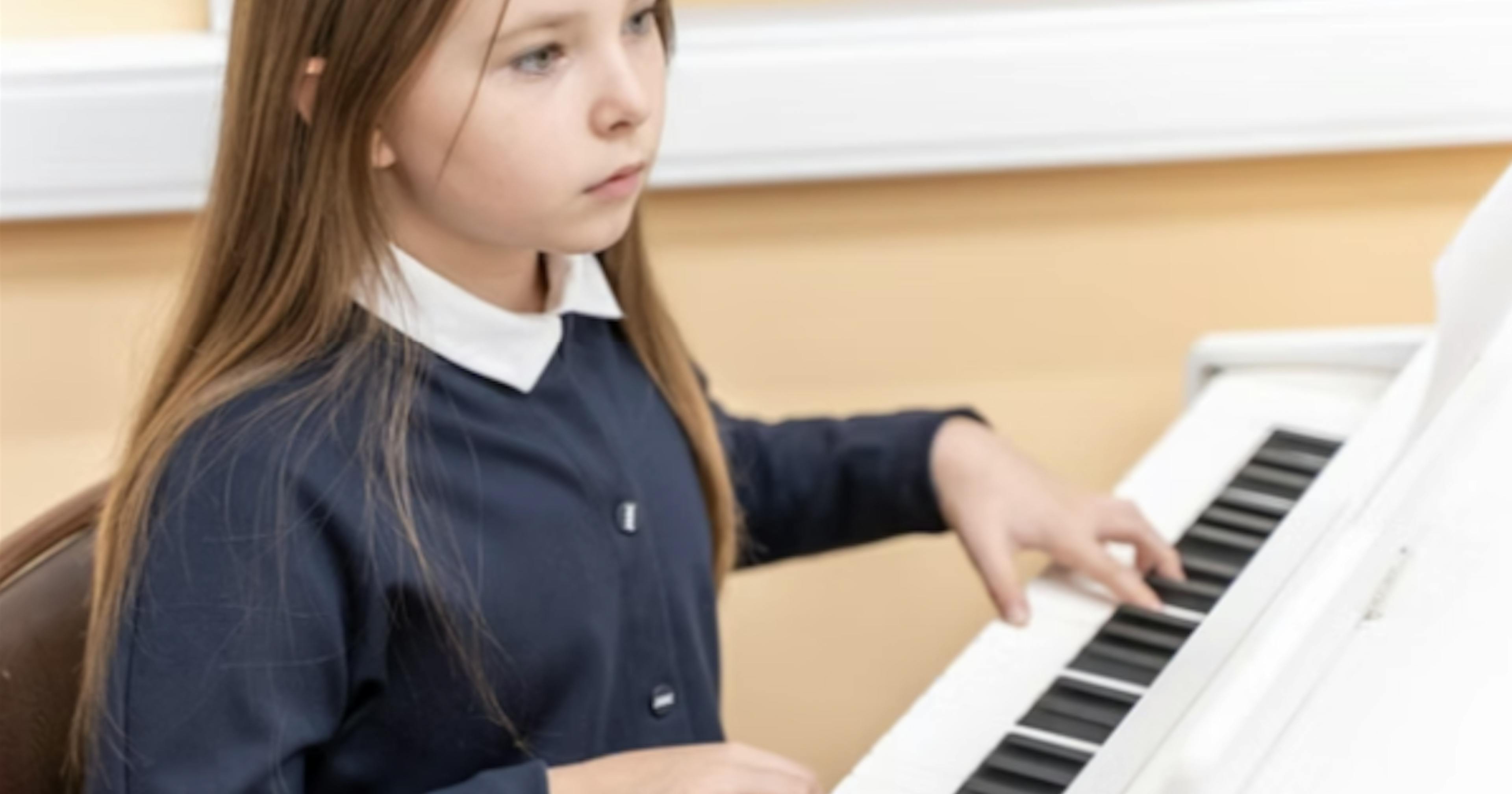  girl learning to play the piano