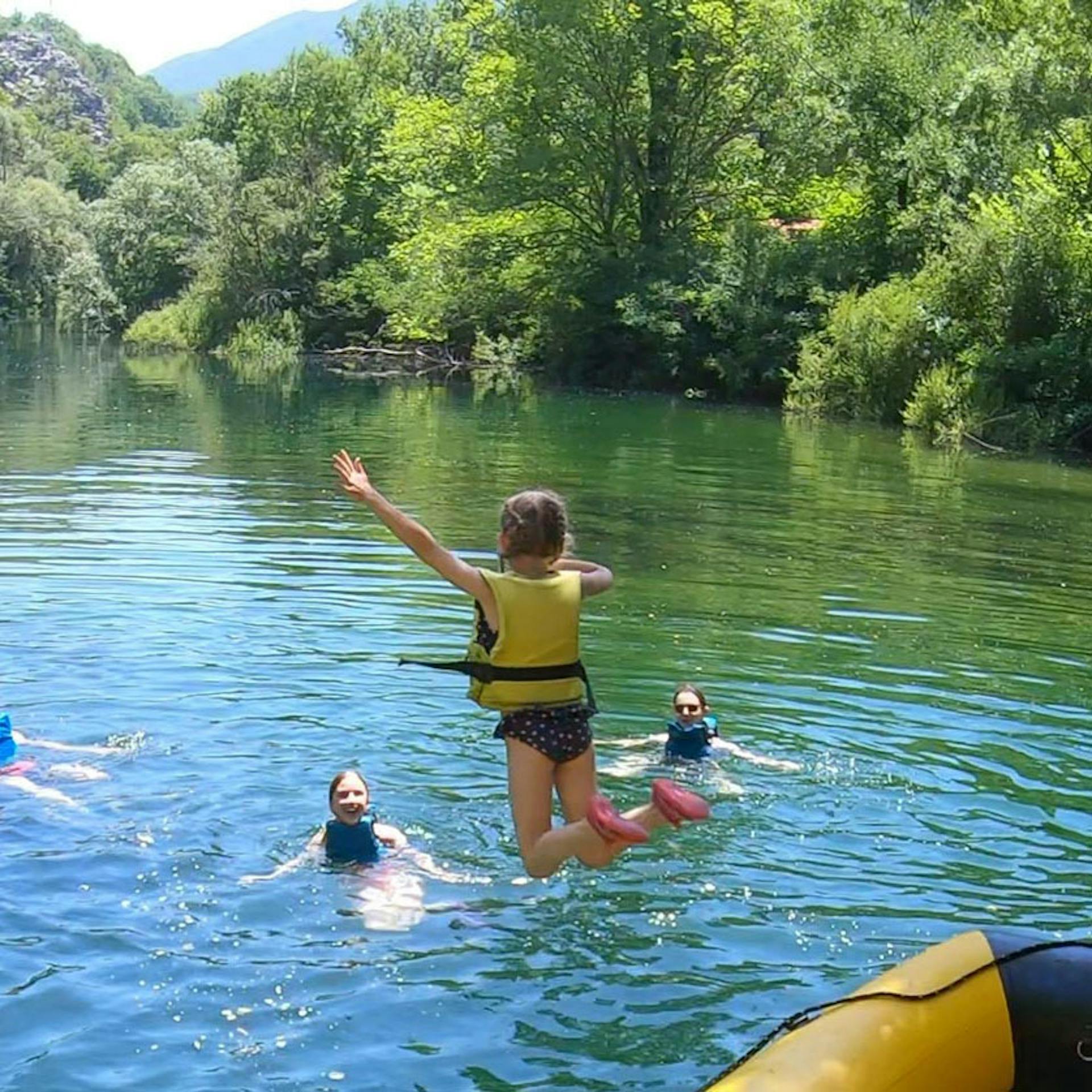 child jumping from a boat on river cetina rafting trip