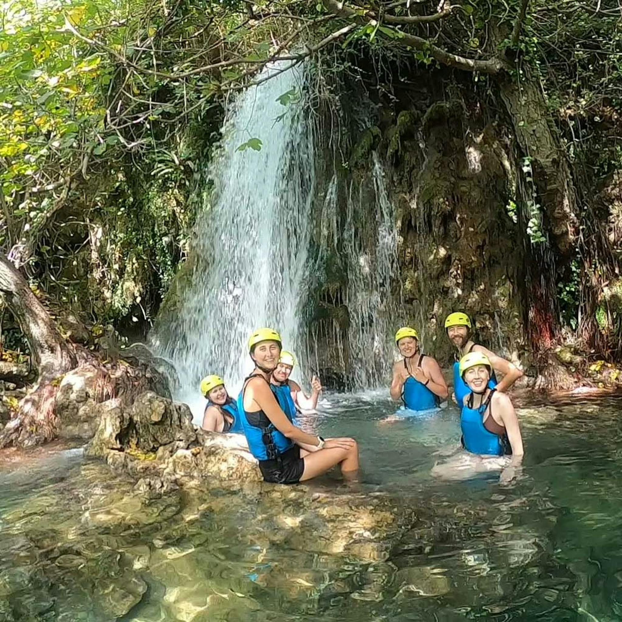 friends taking pictures under waterfall on cetina rafting trip