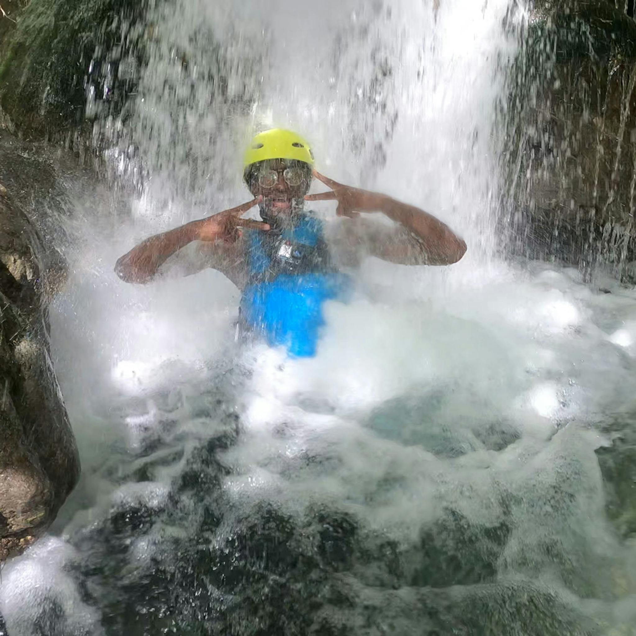 man having fun with under the waterfall on cetina river rafting trip