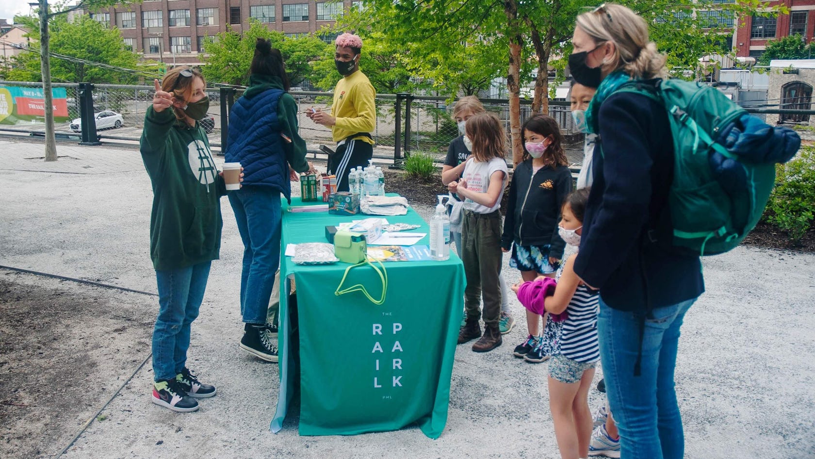 Two people help people at a Rail Park table at the park