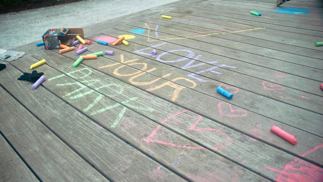 Love Your Park written in colorful chalk on the wooden platforms at the Rail Park