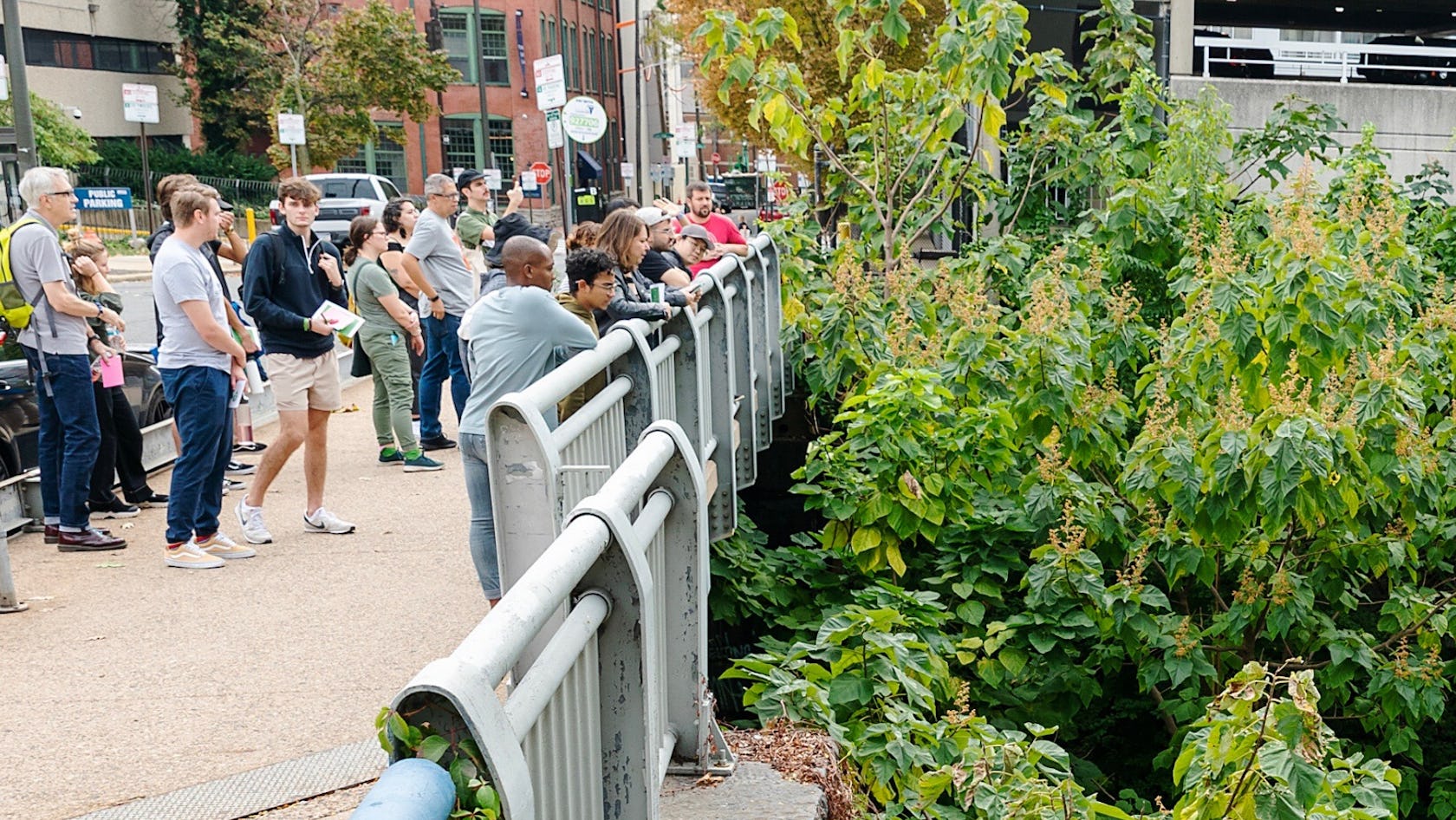 A tour group stands on the street level bridge above the Cut