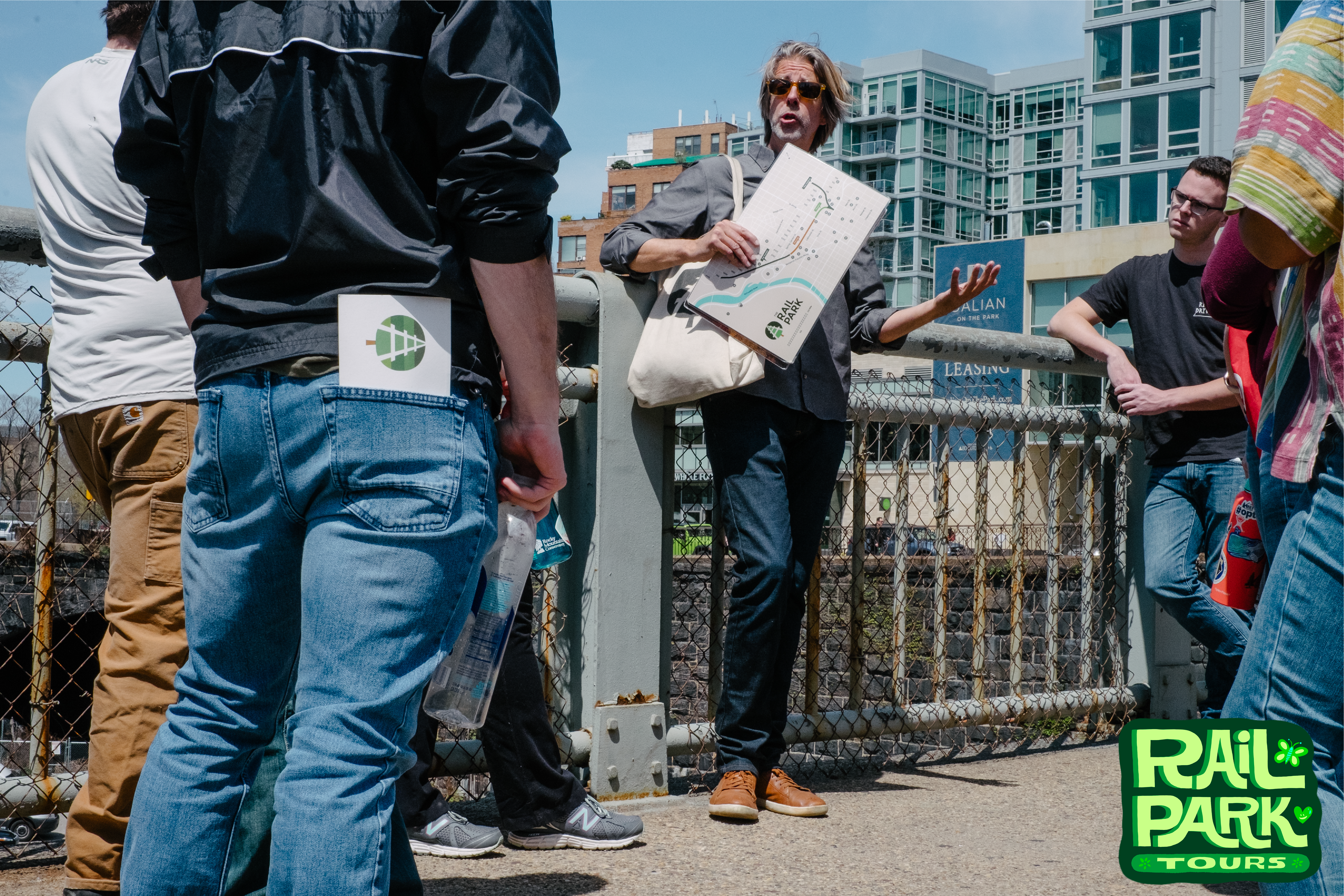 Tour Guide speaking to group while displaying a map.