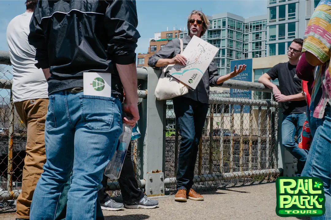 Tour Guide speaking to group while displaying a map.