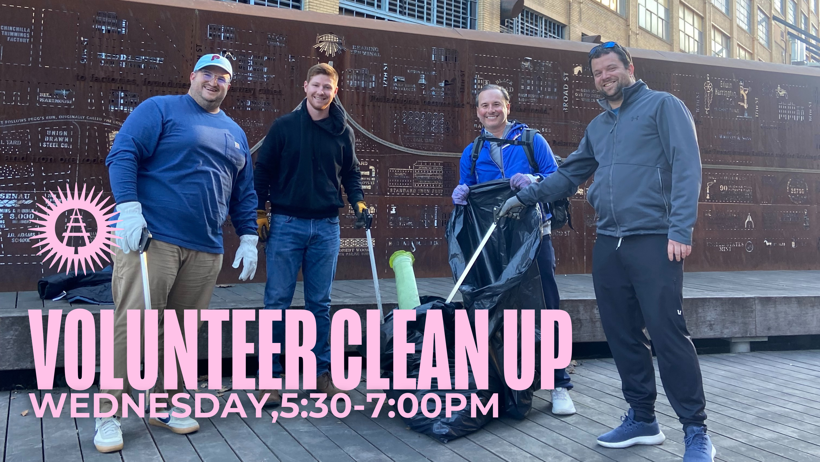 Four volunteers smiling and using trash grabbers to put litter in a garbage bag