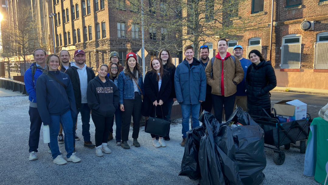 Group of folks posing with all the bags of trash they collected after a clean-up on the park