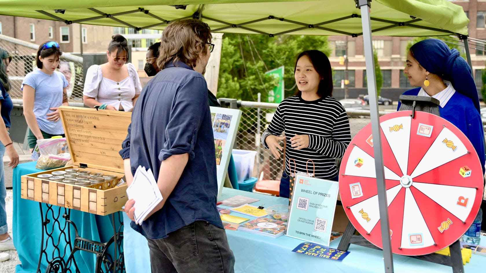 Representatives from Asian Arts Initiative talk to visitors at an event at the Rail Park