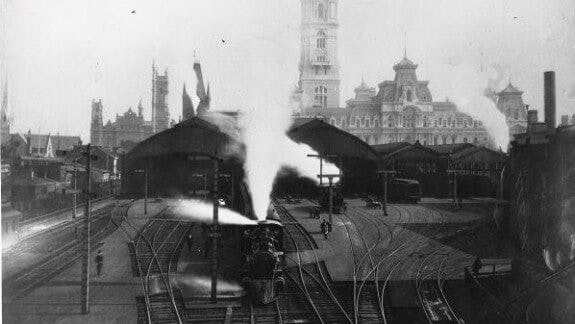 Black and white image of a Locomotive train leaving the Broad Street train shed in 1882