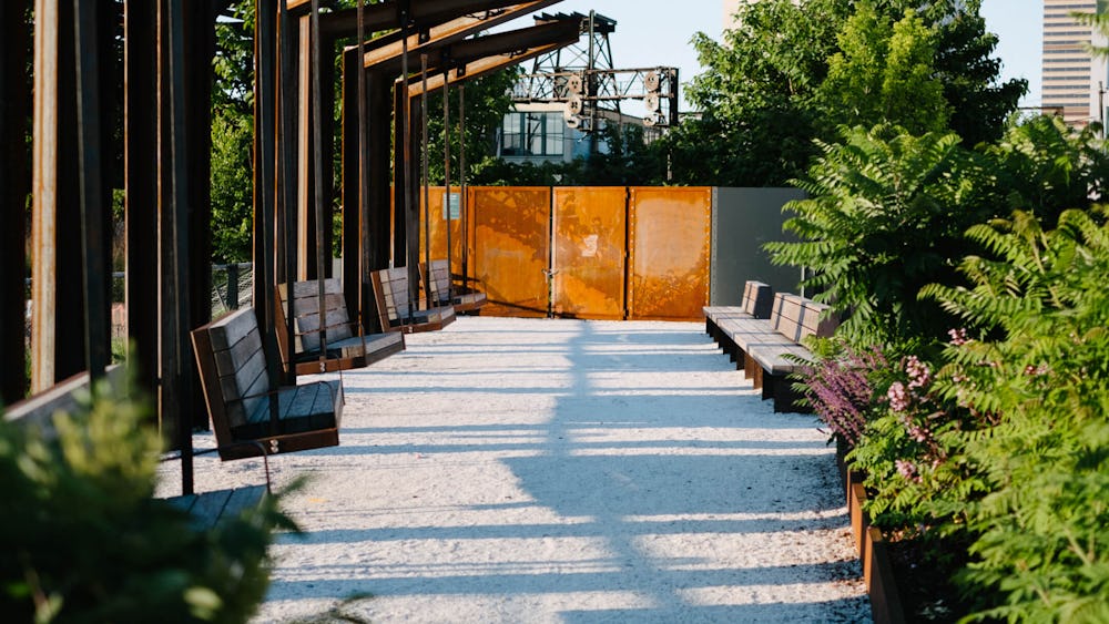 A view of the swing benches at the Rail Park, surrounded by plants