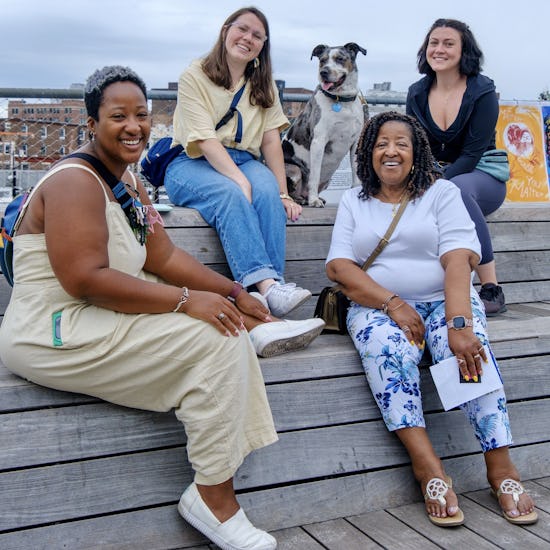 A group of smiling women and a dog
