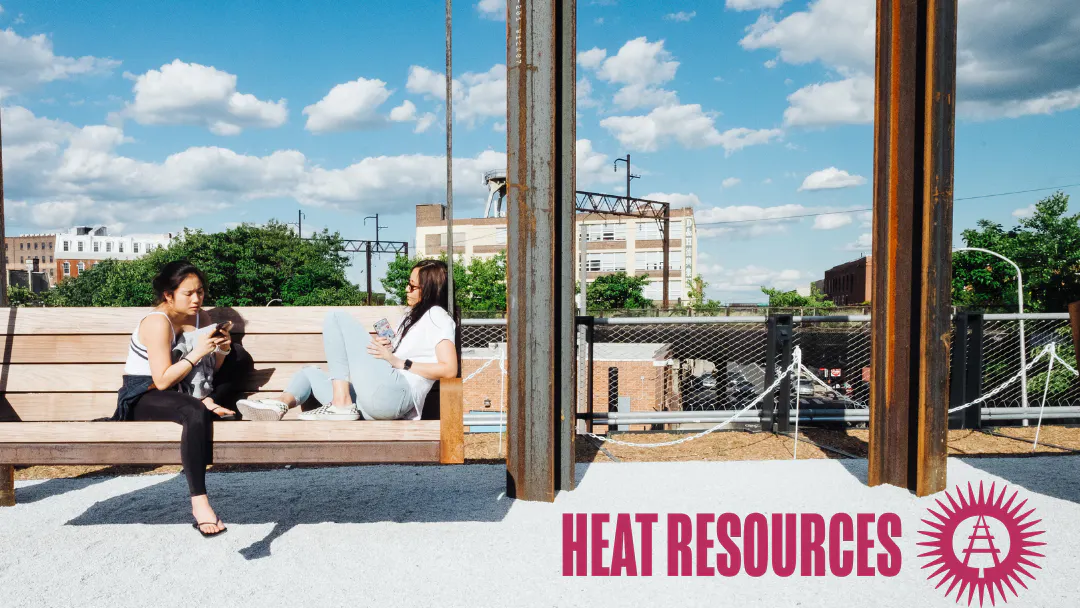 Two people relax on a wooden bench at the Rail Park on a sunny day beneath a blue sky, with the title "Heat Resources" and the Friends of the Rail Park logo displayed at the bottom.