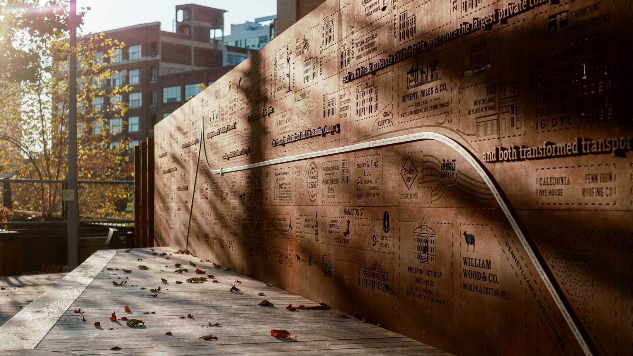 The Story Wall at the Rail Park, an 80 foot galvanized steel wall with laser cut imagery of a 1895 city atlas