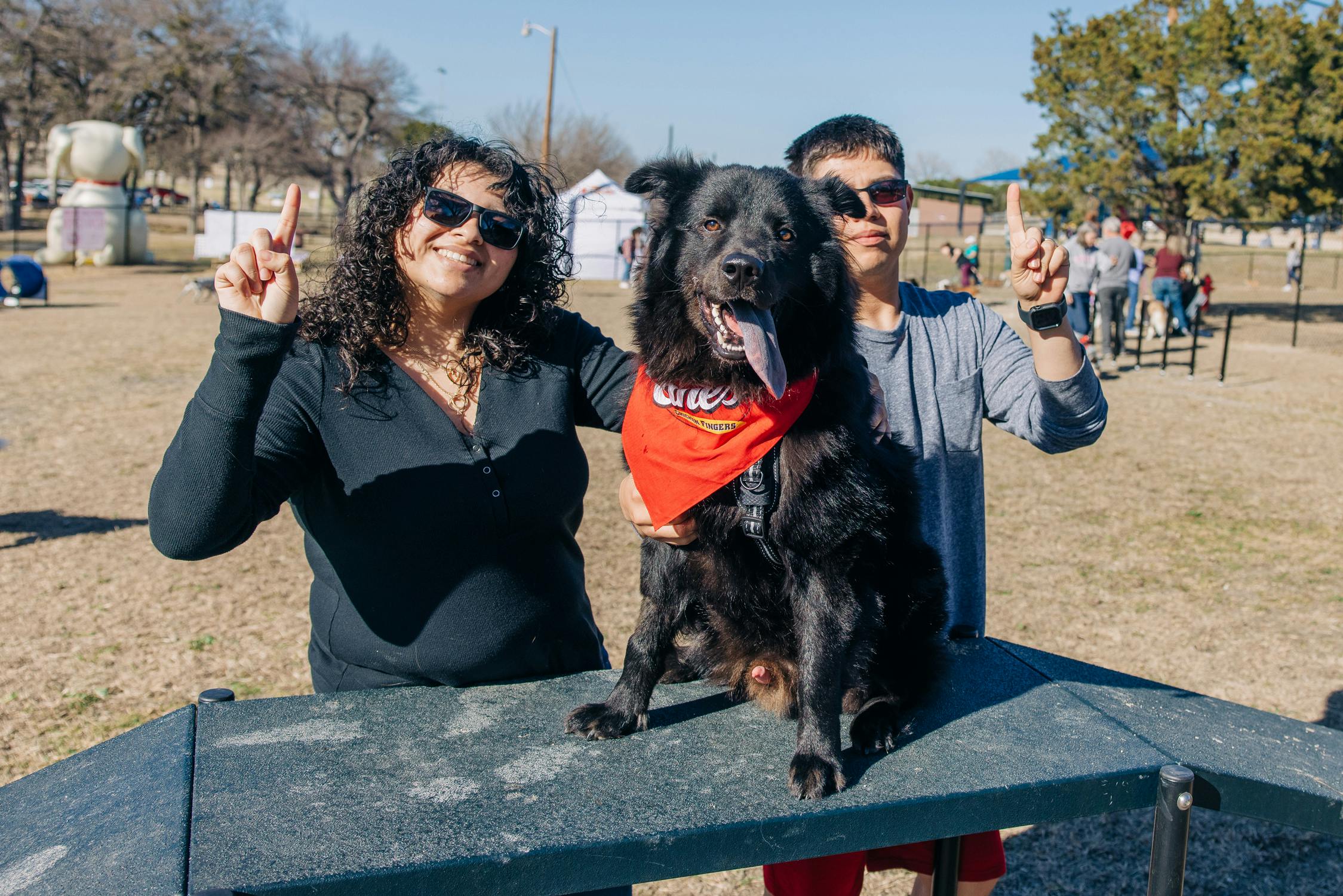Owners and their dogs enjoying the grand opening of the Raising Cane's Dog Park