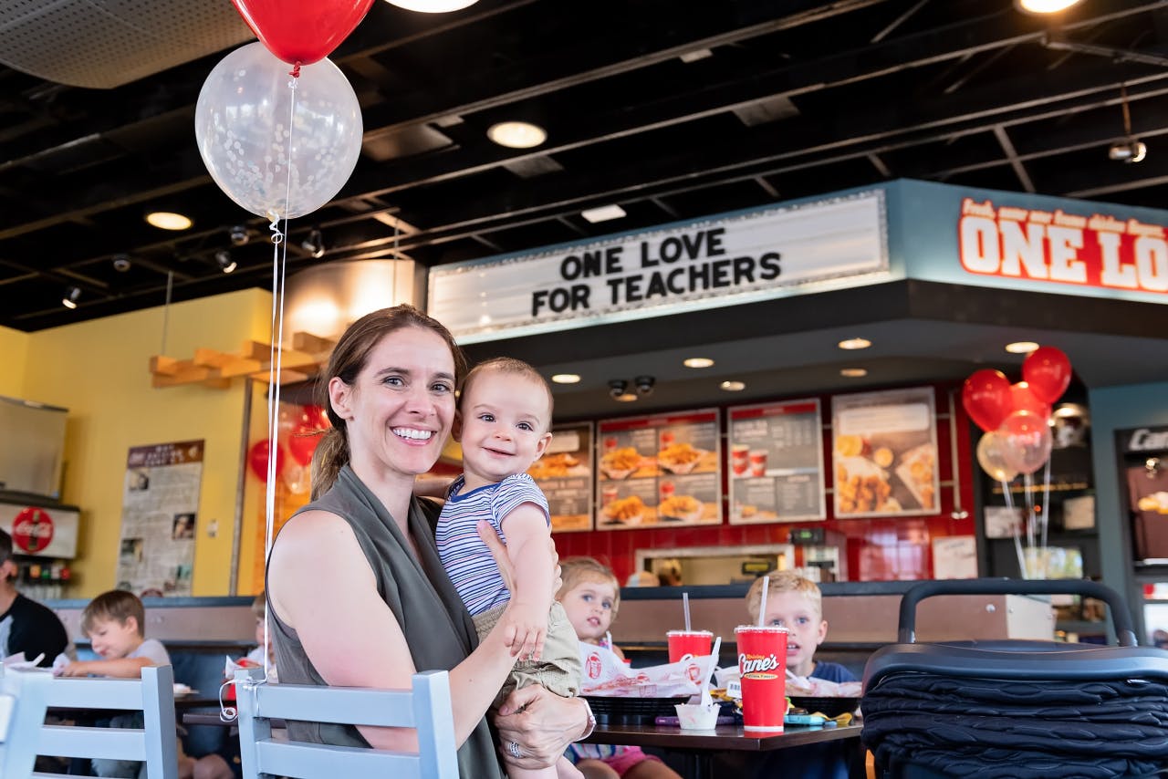 Teacher eating at a Raising Cane's restaurant with baby.