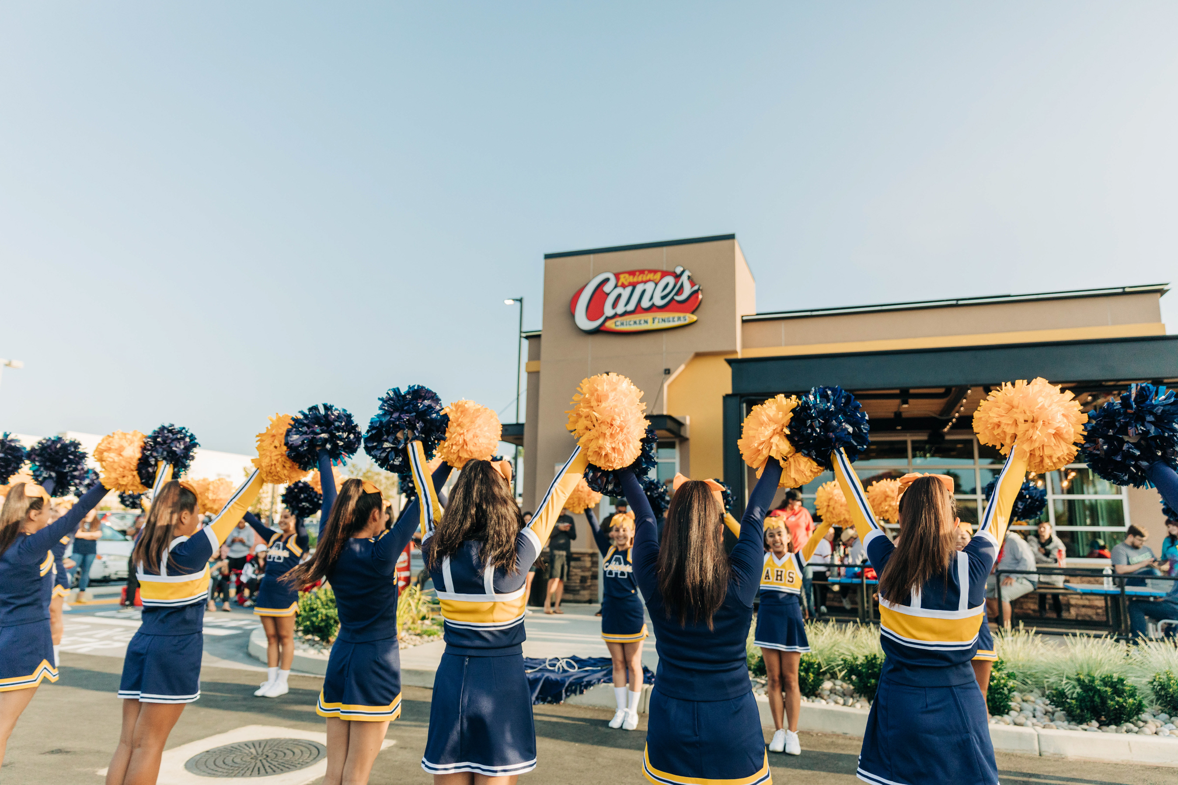 Cheerleaders outside of a Raising Cane's