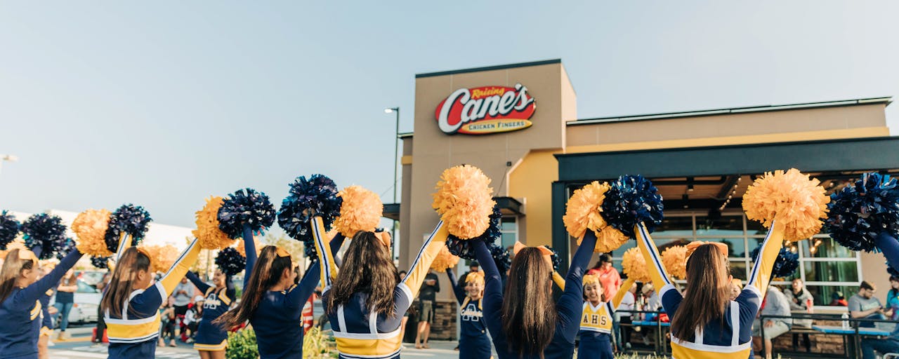 Cheerleaders outside of a Raising Cane's