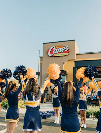 Cheerleaders outside of a Raising Cane's