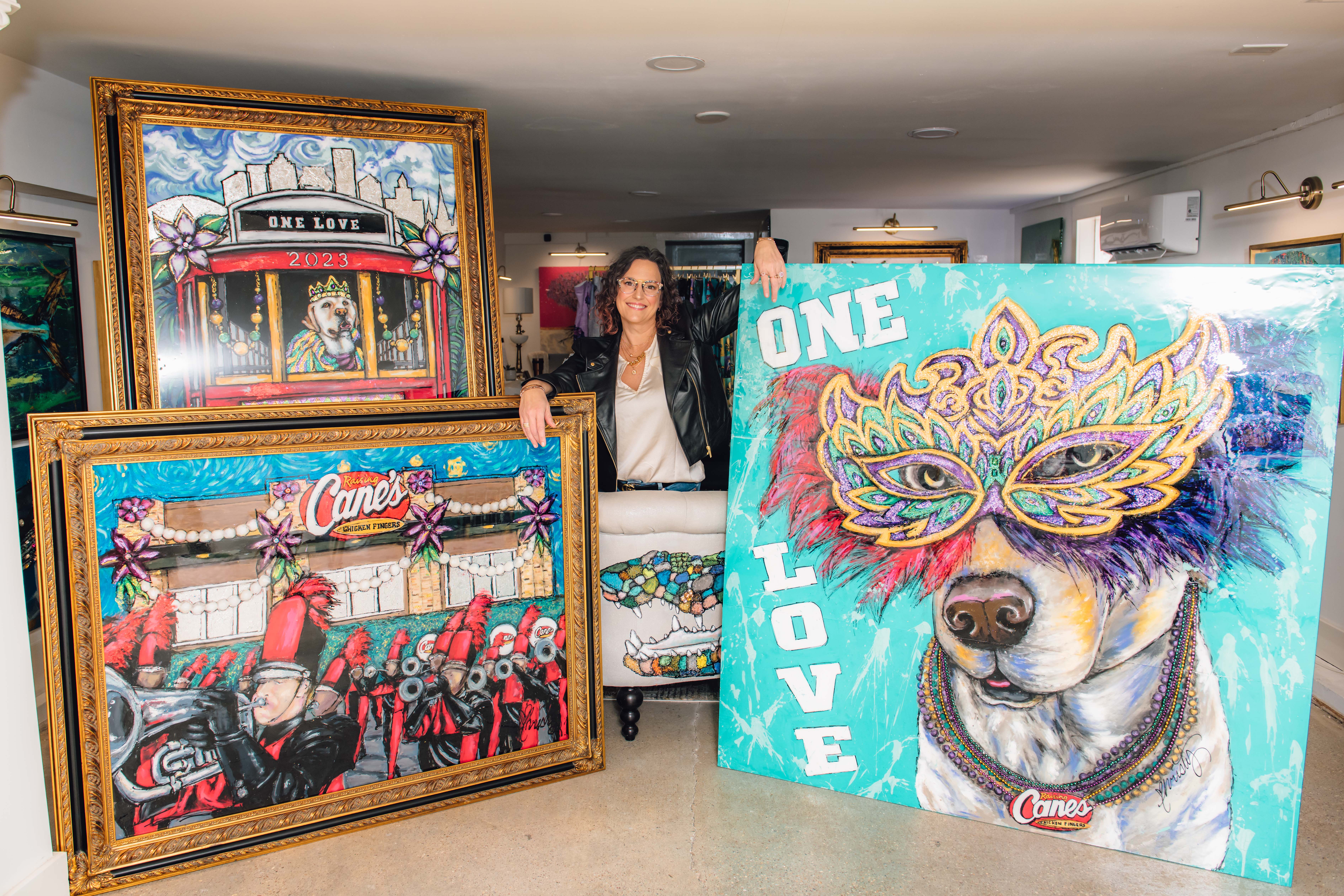 Artist Christy Boutte standing with her custom Mardi Gras Paintings for Raising Cane's.