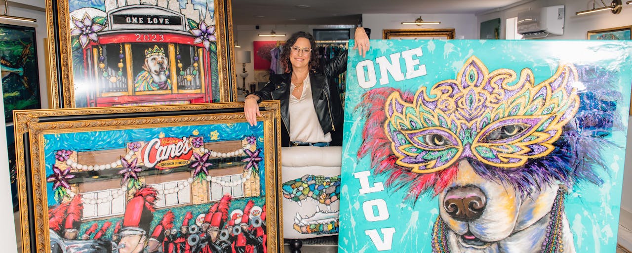 Artist Christy Boutte standing with her custom Mardi Gras Paintings for Raising Cane's.