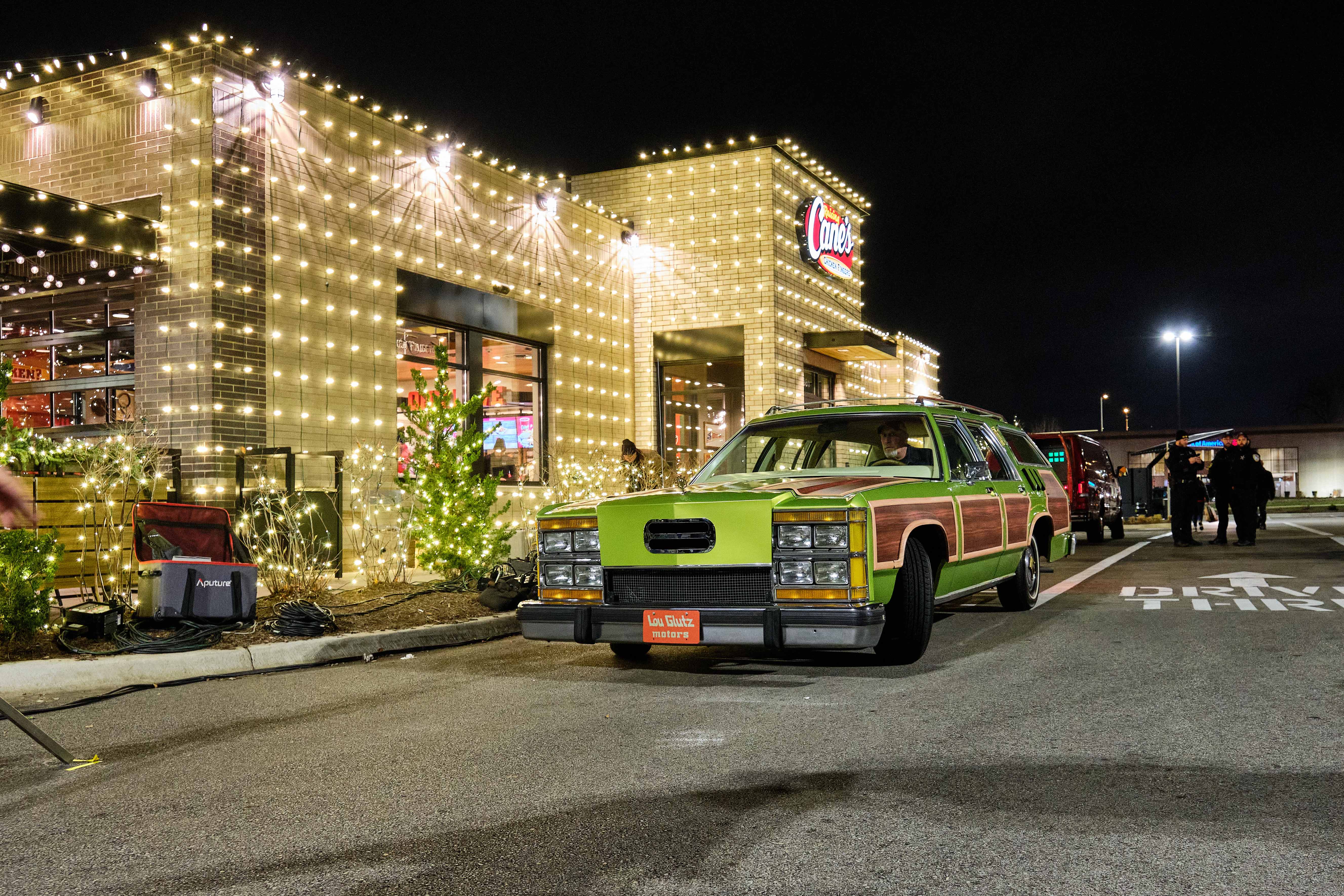 Griswold's station wagon in the drive-through of Raising Cane's decorated in holiday lights