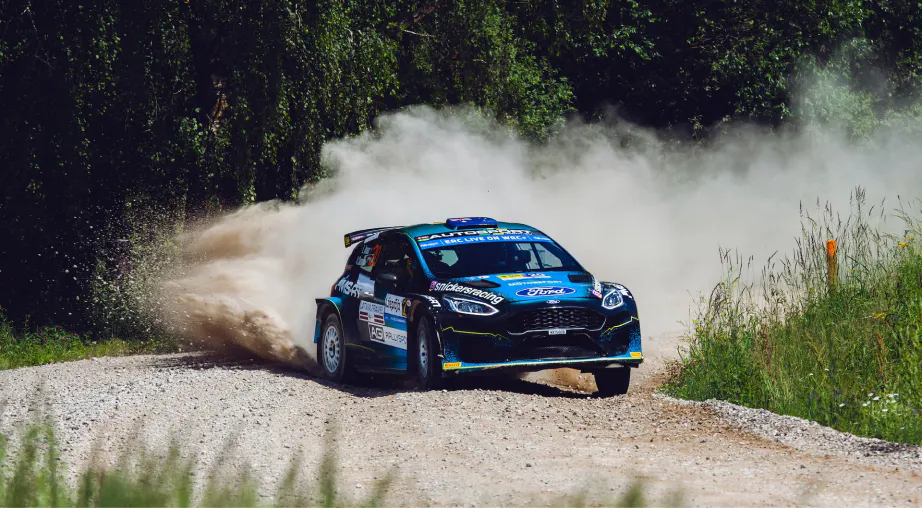 Voiture de rallye bleue qui fait un dérapage