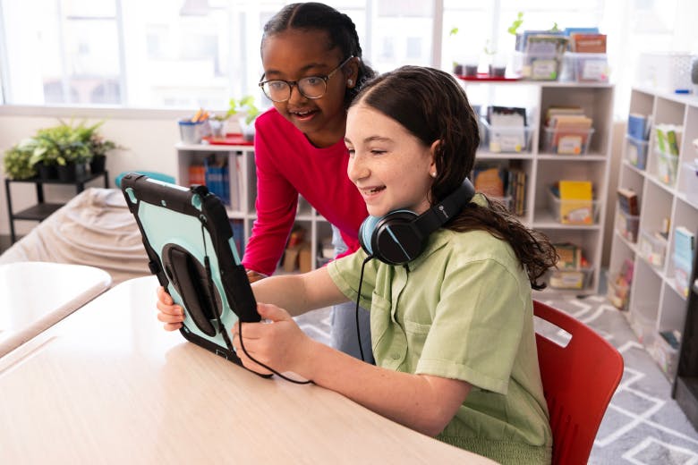 Students smiling and looking at an iPad