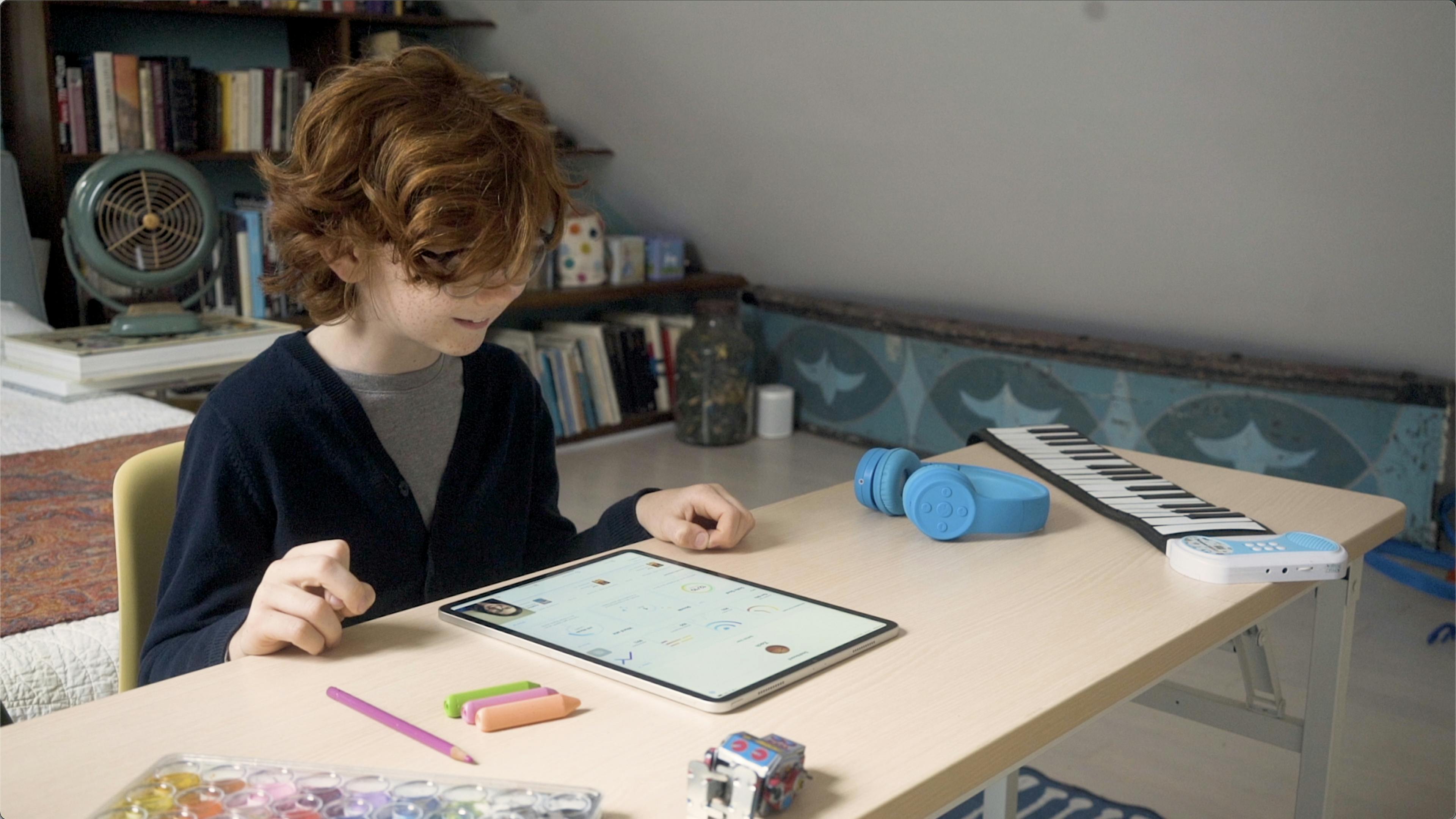 A student sits at his desk at home