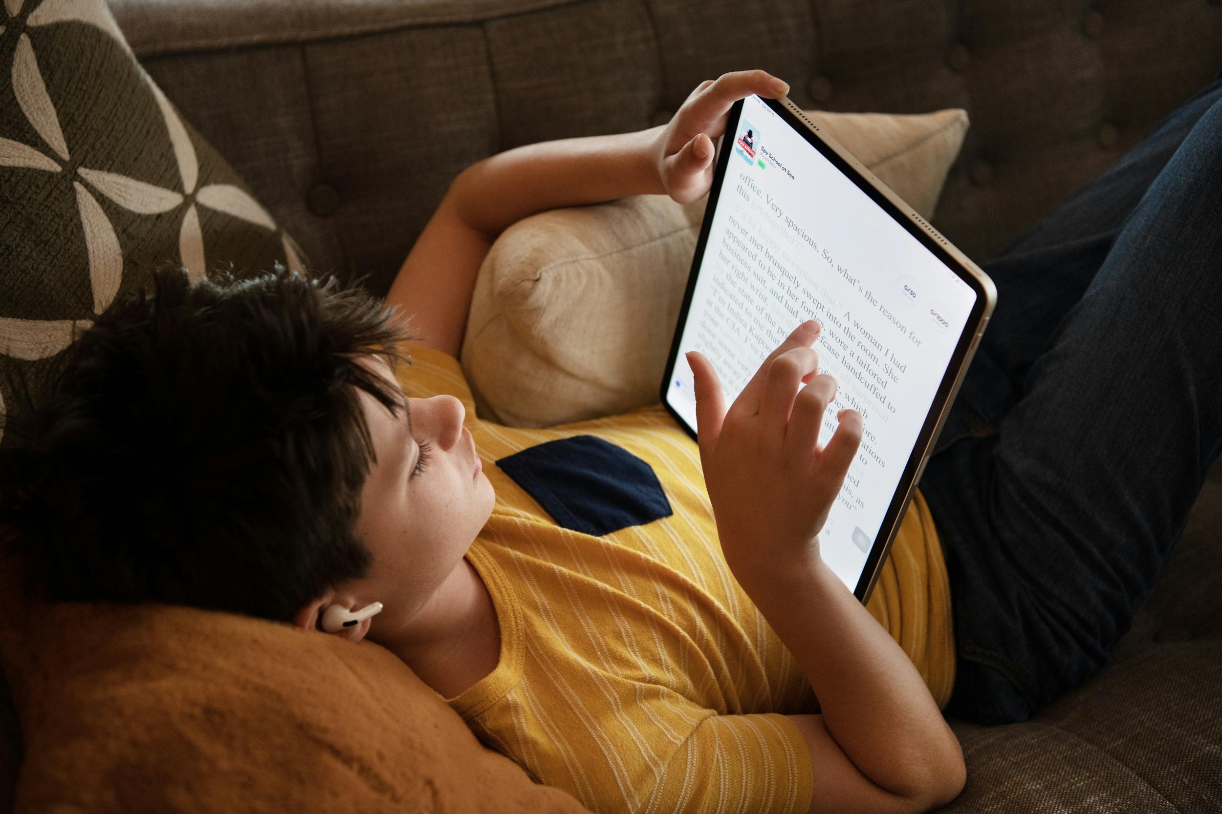 A young reader is focused on his iPad