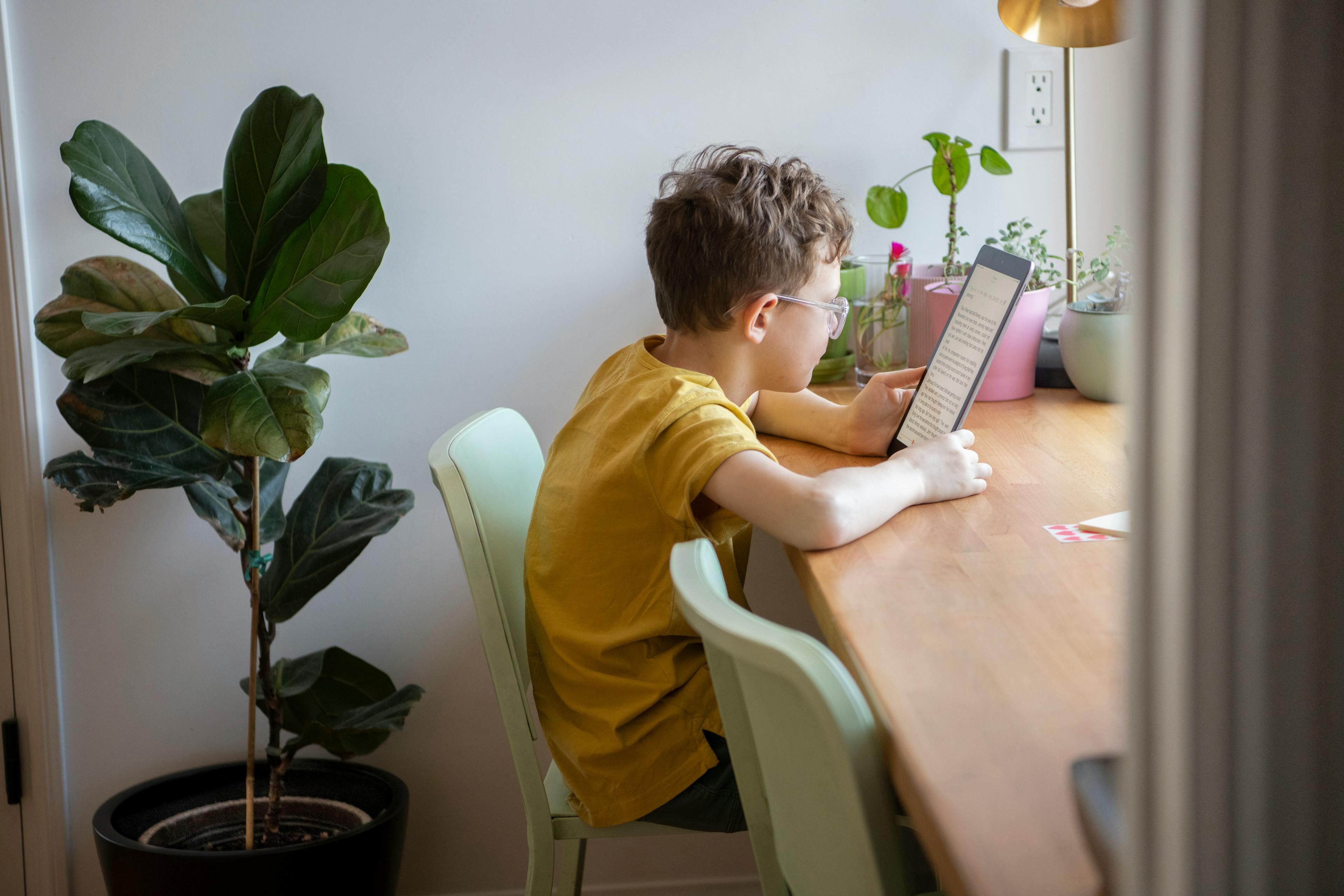 A child reads at a desk at home