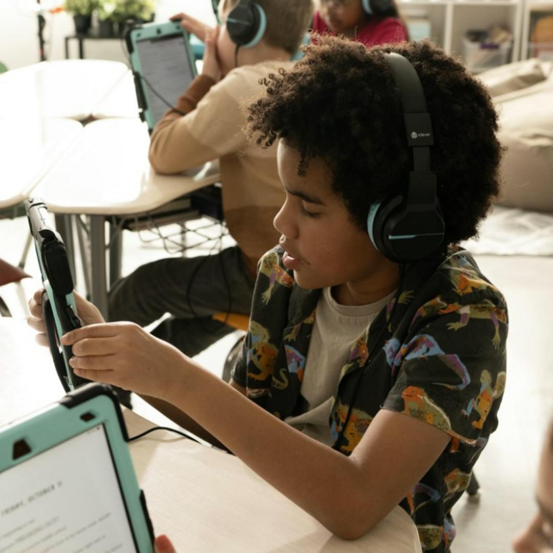 A boy reads happily on his iPad