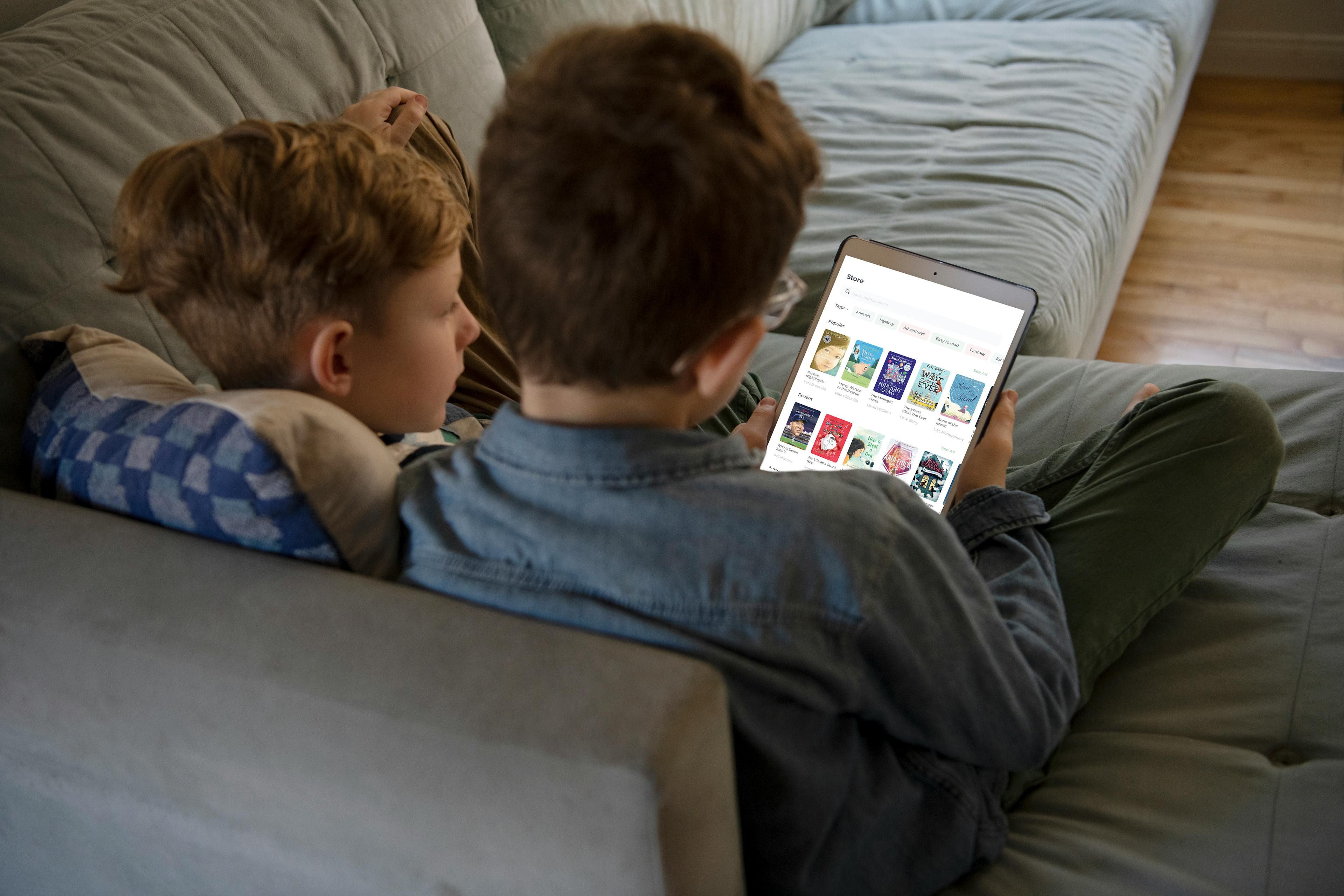 Two children read together at home