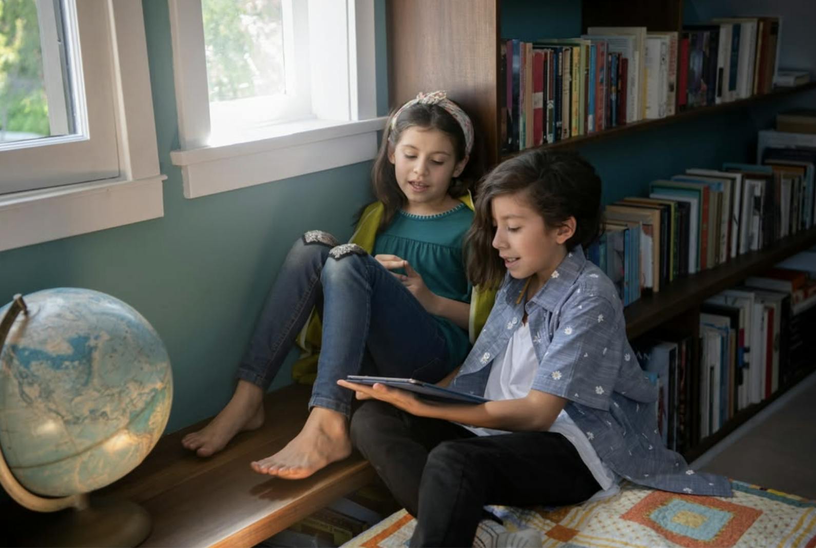 Two children read at home together
