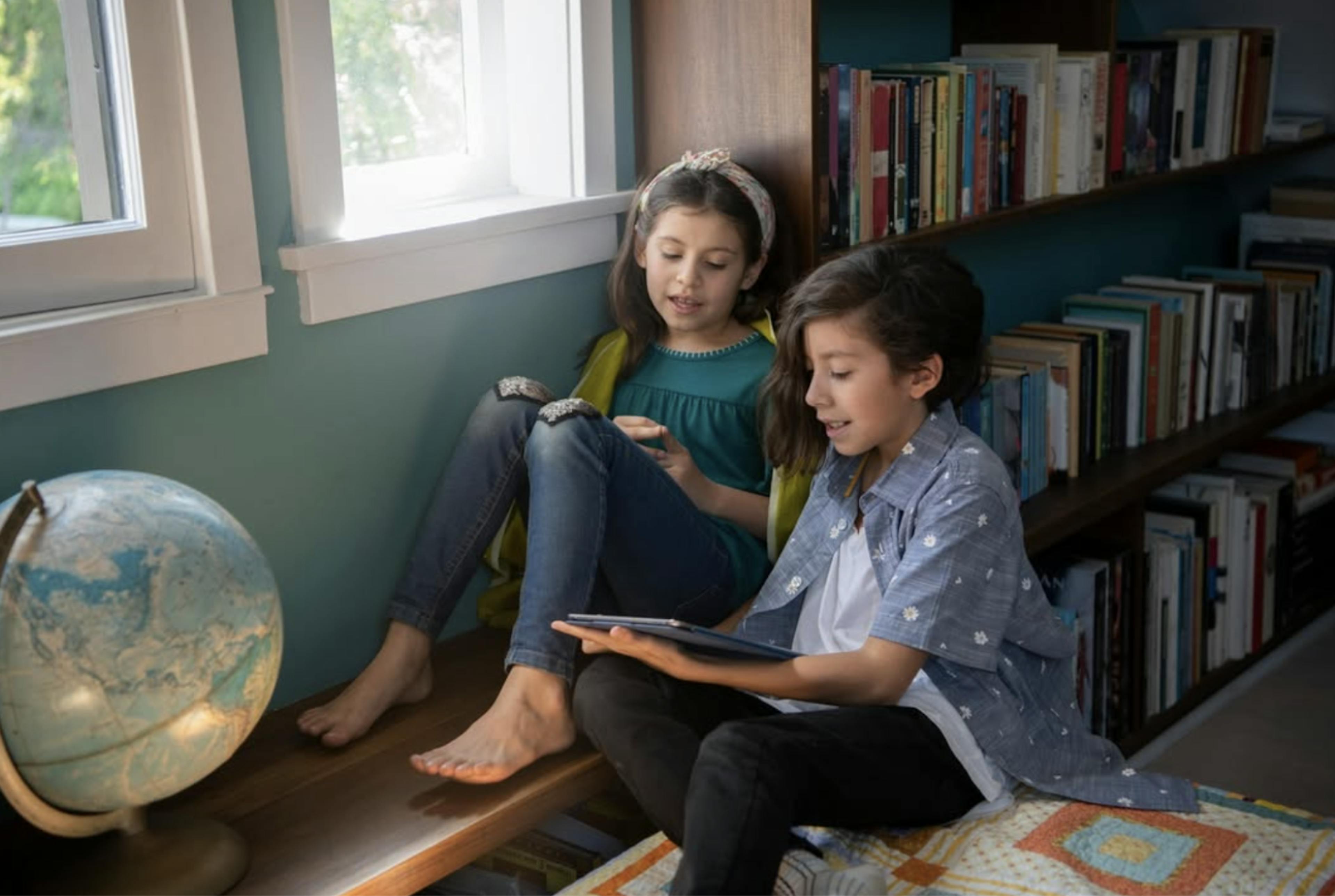 Two children read at home together