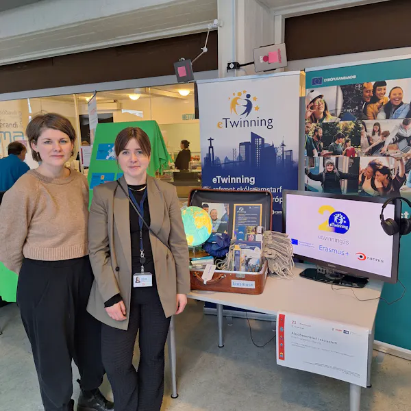 Tvær konur standa við bás