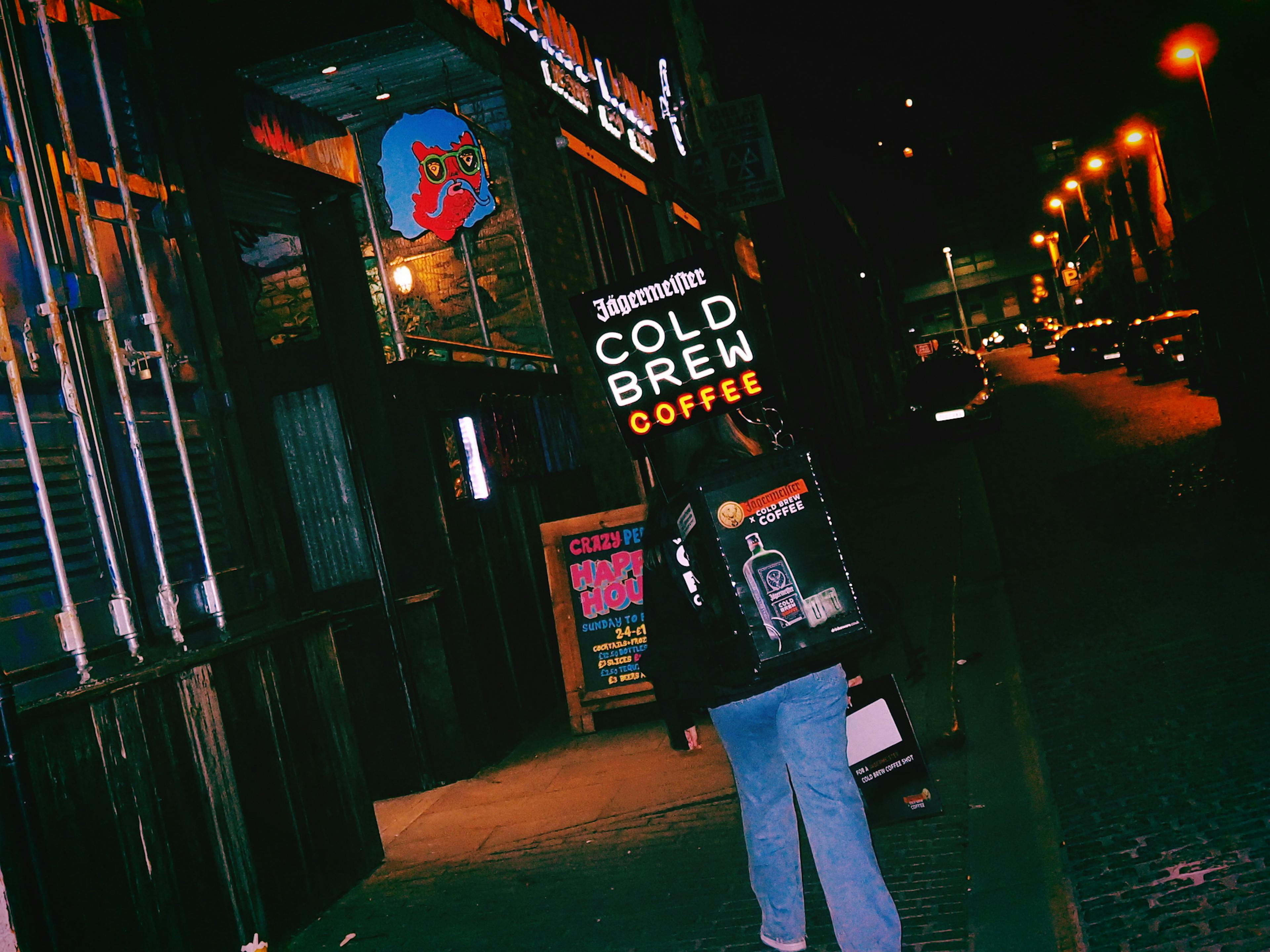 student outside on a dark street by a pub