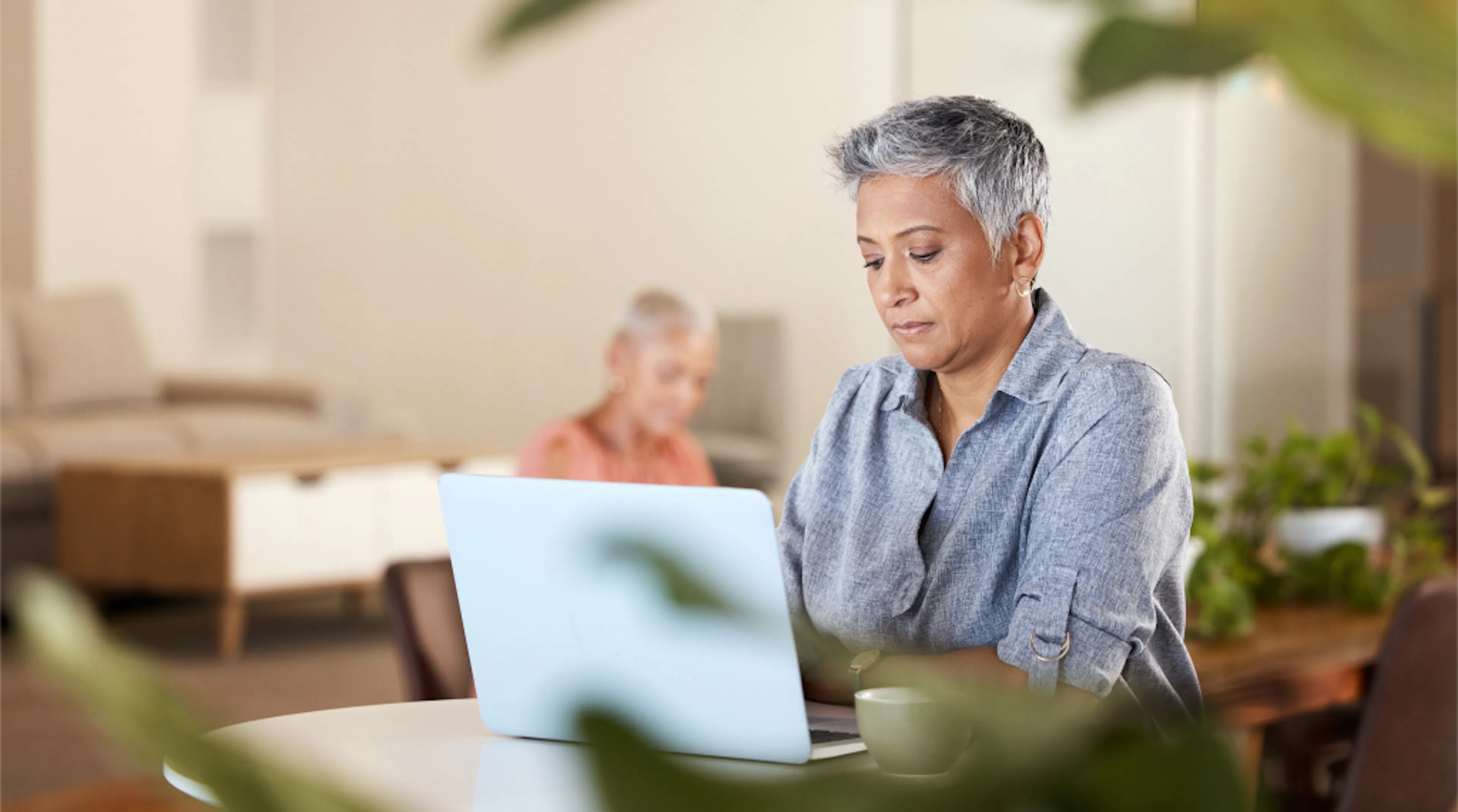 A female office worker sits at her laptop in an office environment