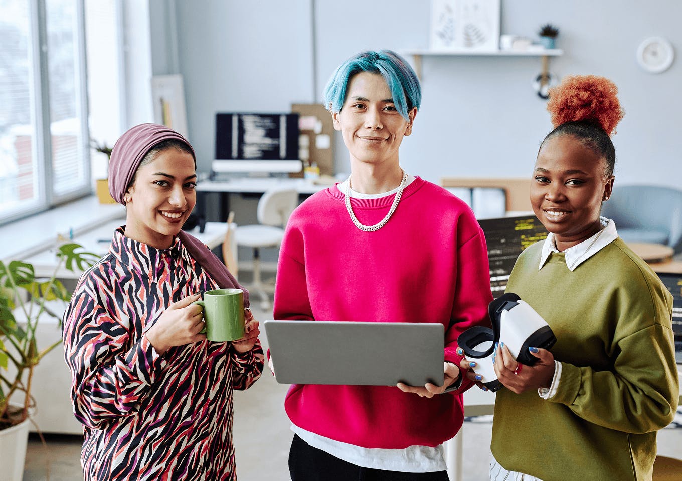 Young co-workers stand together in an office environment