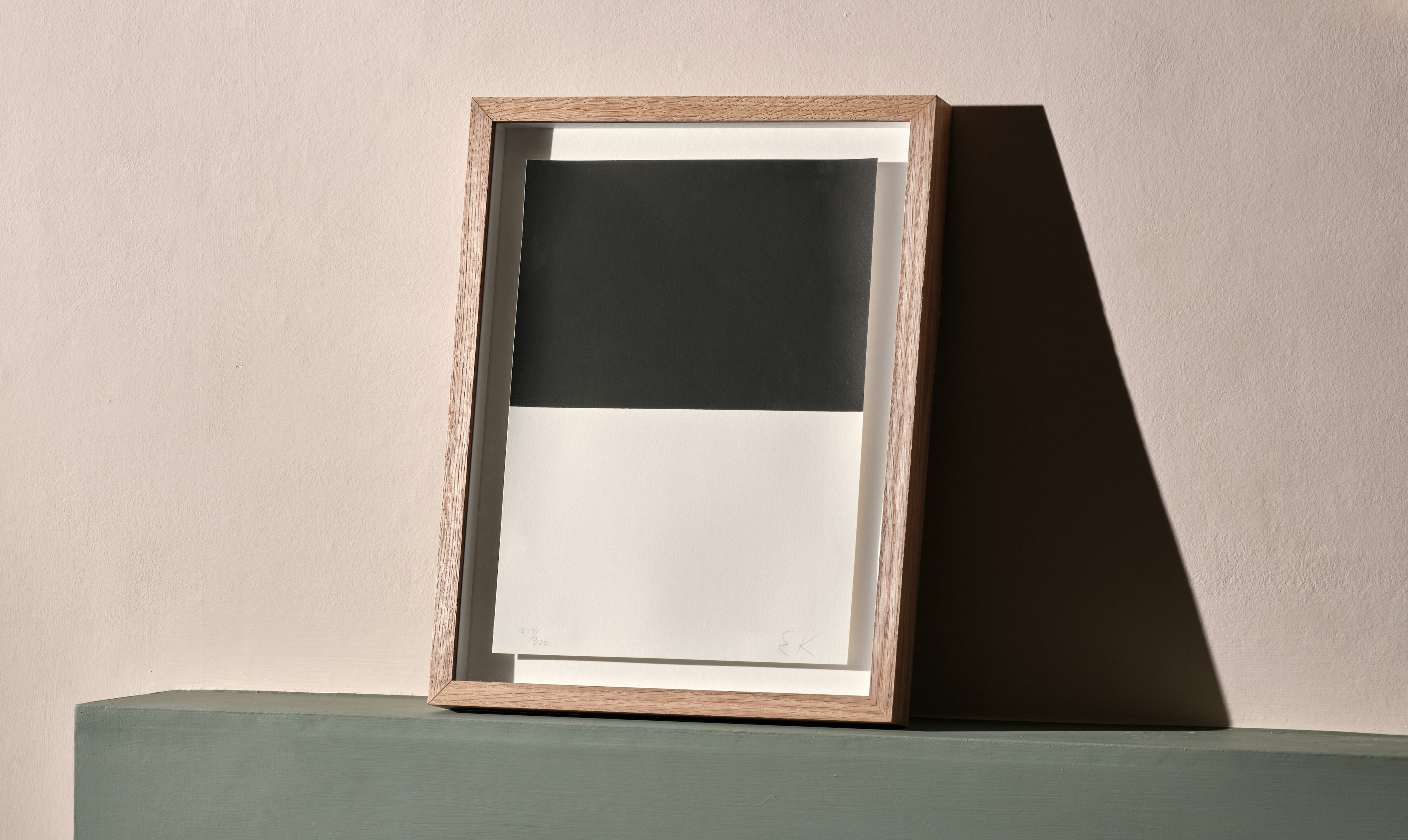 Installation photo of framed abstract screenprint by Ellsworth Kelly with upper half printed in black and lower half white.