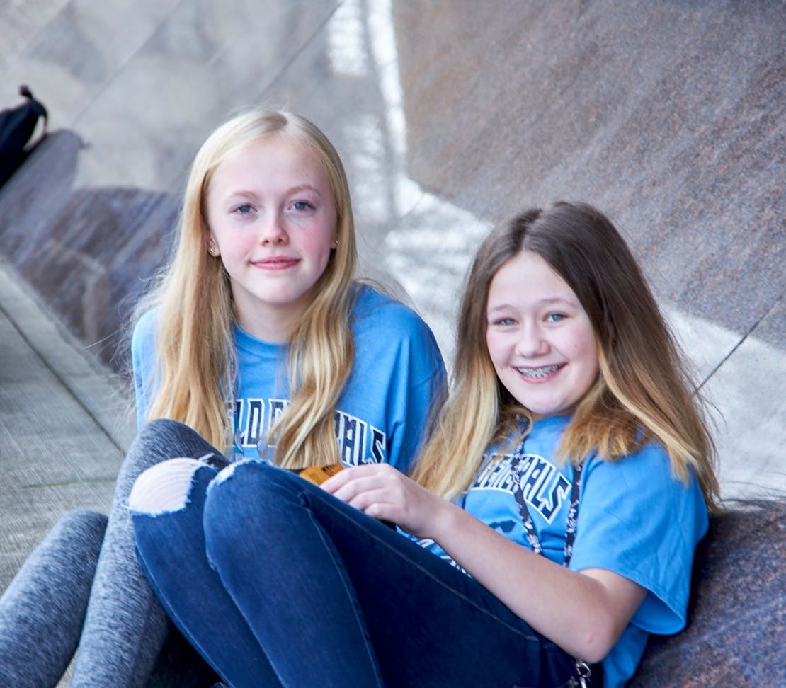 2 girls in blue shirts