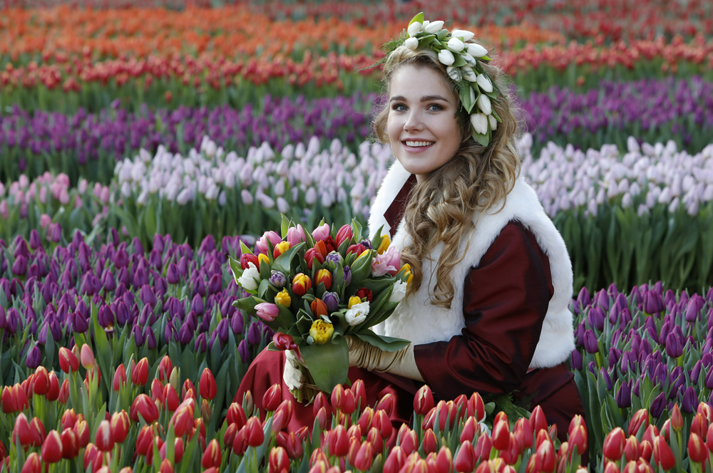 Zittende vrouw in tulpenveld