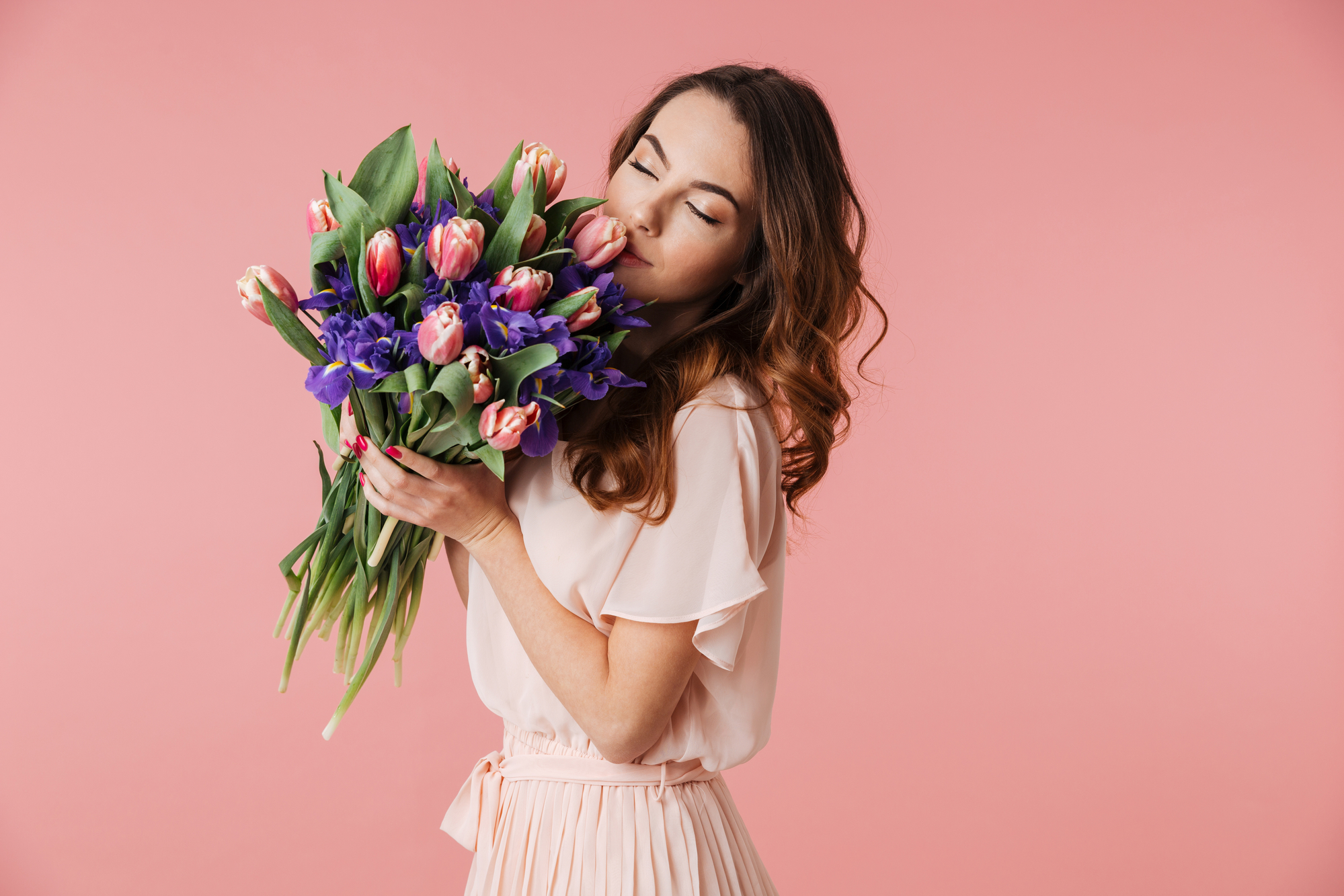 Vrouw met boeket van roze en paarse tulpen