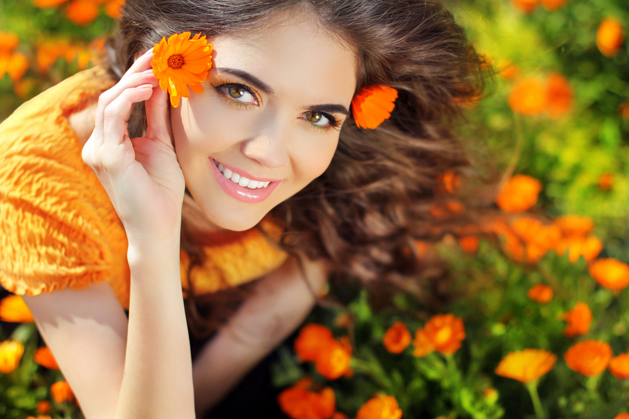 Een vrouw in een veld met oranje gerbera's