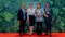 Group of people at award ceremony posing with trophies