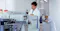 A male standing by an imaging machine in a laboratory