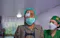 Patient walking down corridor guided by health worker post surgery.