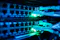 The image shows a close-up view of network cables plugged into a server or network switch, with glowing green indicator lights. This context suggests a focus on digital infrastructure, data connectivity, and information technology, highlighting the importance of robust networking systems in supporting modern digital transformation and smart technologies.