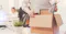 man putting items in cardboard box