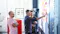 Three people in an office meeting room. One man is pointing to a map with sticky notes.