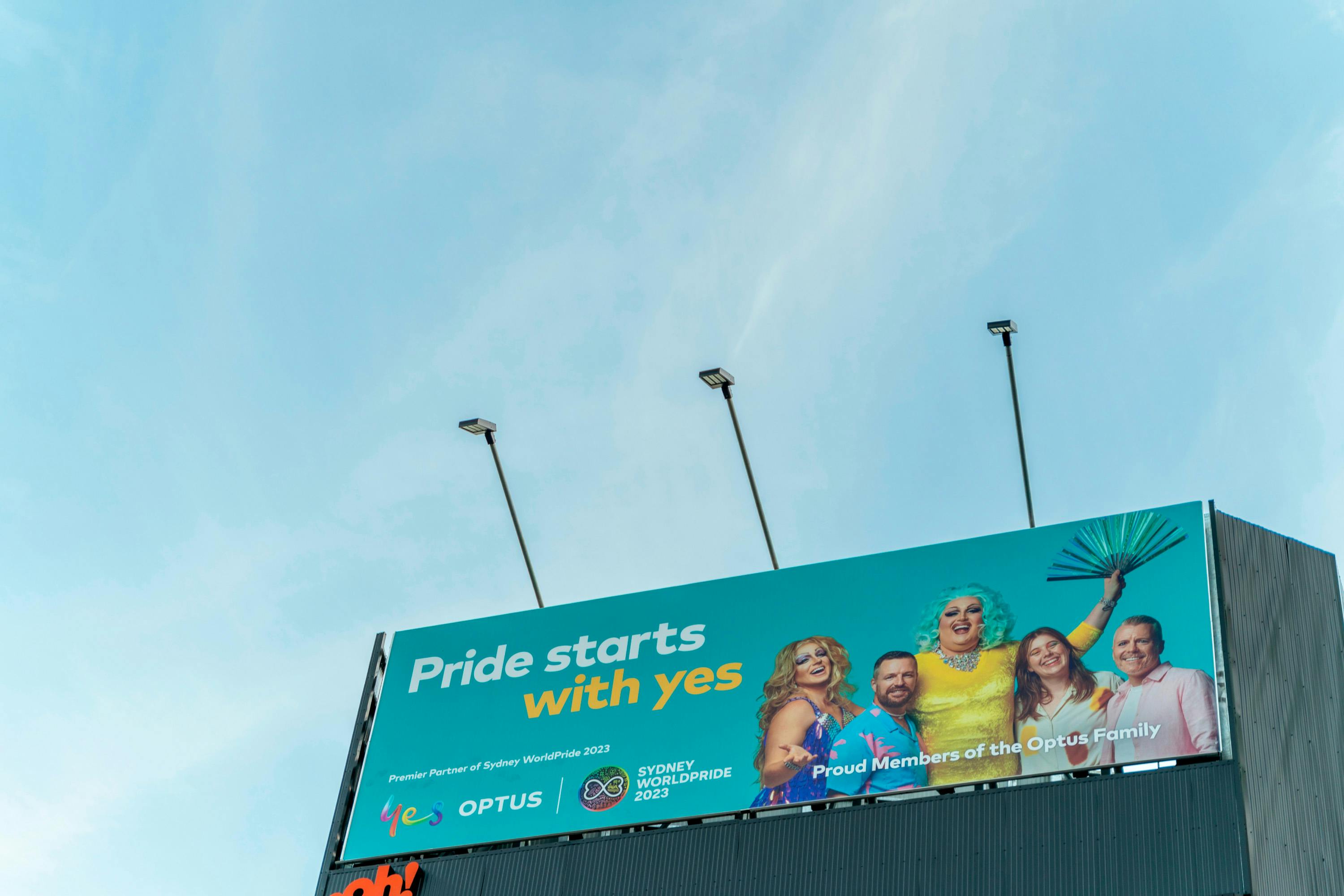 A photo of a billboard featuring the Optus x SydneyWorldPride campaign: Pride starts with yes